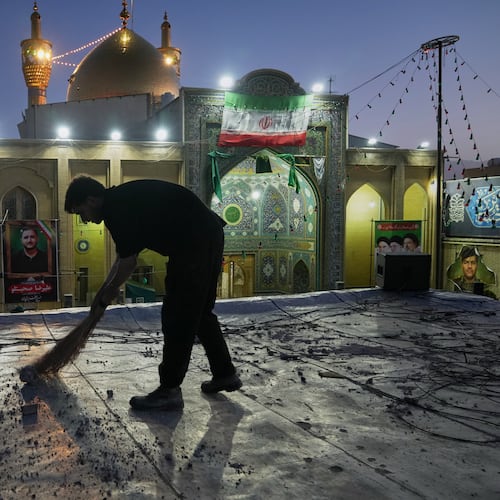 A worker cleans an area within the Grand Hosseiniyeh complex, with the mosque visible in the background, that officials say was hit by U.S.-Israeli airstrikes Tuesday in Zanjan, Iran, Saturday, April 4, 2026. (AP Photo/Francisco Seco)