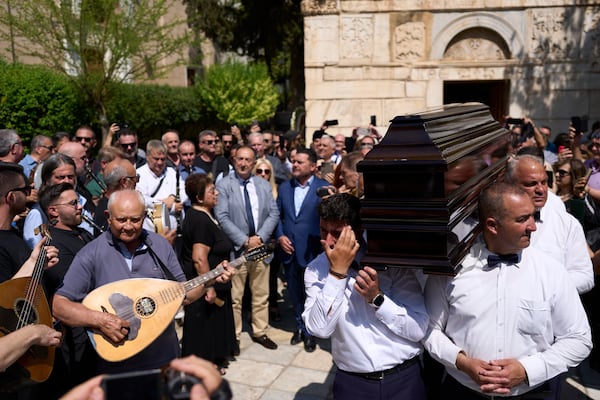 Musicians play next to the coffin of renowned clarinetist Petroloukas Chalkias, who died at 90 over the weekend, during his lay in state at Athens Cathedral on Wednesday, June 18, 2025. (AP Photo/Petros Giannakouris)