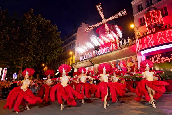 Dancers perform outside the Moulin Rouge cabaret to mark the mill's huge sails return to operation, Thursday July 10, 2025. (Moulin Rouge via AP)
