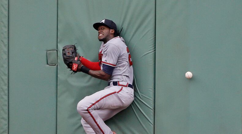 Atlanta Braves center fielder Cameron Maybin crashes into the wall as he is unable to catch a triple by Boston Red Sox's Mookie Betts in the sixth inning of a baseball game at Fenway Park Tuesday, June 16, 2015, in Boston. (AP Photo/Elise Amendola)