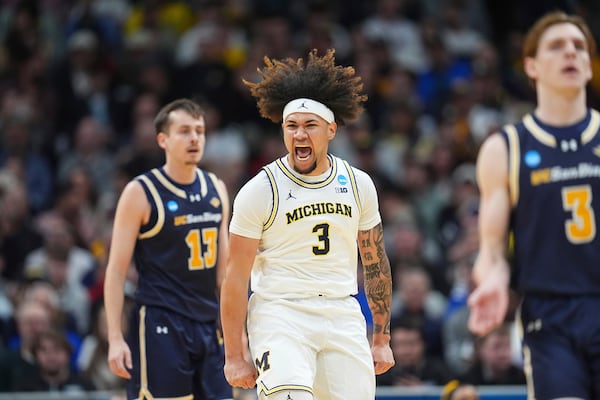 Michigan guard Tre Donaldson, center, reacts after scoring a basket as UC San Diego guards Tyler McGhie, back, and Hayden Gray drop back on offense during the first half in the first round of the NCAA college basketball tournament Thursday, March 20, 2025, in Denver. (AP Photo/David Zalubowski)