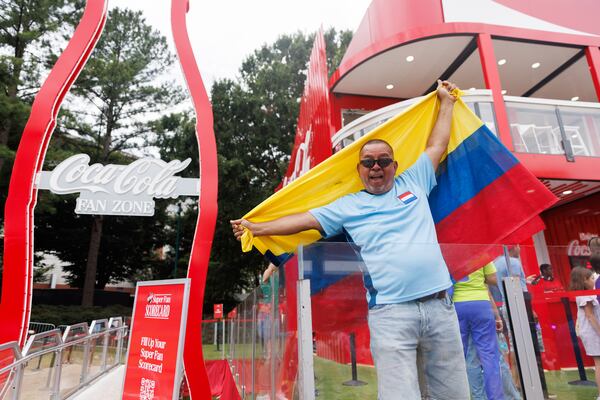 Eddie Erazo poses for a photo in front of Coca-Cola Fan Zone at the FIFA Fan Fest with the Colombian flag, Thursday, June 18, 2026. (Estela Muñoz/AJC)