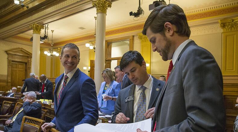 Georgia Sen. Greg Dolezal, from left, Sen. Matt Brass and Sen. Brian Strickland talk among themselves in the Senate chambers.  (ALYSSA POINTER/ALYSSA.POINTER@AJC.COM)