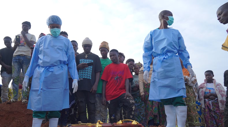 People dressed in protective gear prepare to lower into a grave the coffin containing the remains of 3-year-old Mave Mercienne, who died of Ebola, in Bunia, Ituri province, eastern Congo, Tuesday, Aug. 18, 2026. (AP Photo/Dieudonne Dirole)