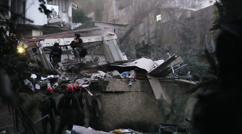 Israeli security forces and rescue teams work amid the rubble of a residential building struck by an Iranian missile in Haifa, Israel, Sunday, April 5, 2026. (AP Photo/Ariel Schalit)