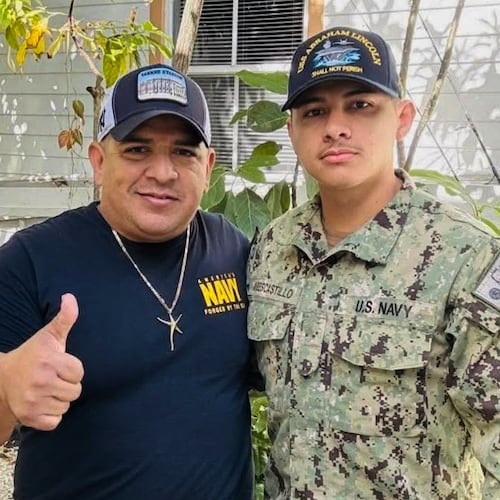 In this photo courtesy of Katherine Delgado shows her step-father Luis Manuel Aviles, left, and her brother Joshua Aviles stand outside their home in Oct. 2025, shortly before Joshua deployed on the USS Lincoln the following month in Key West, Fla. (Katherine Delgado via the AP)