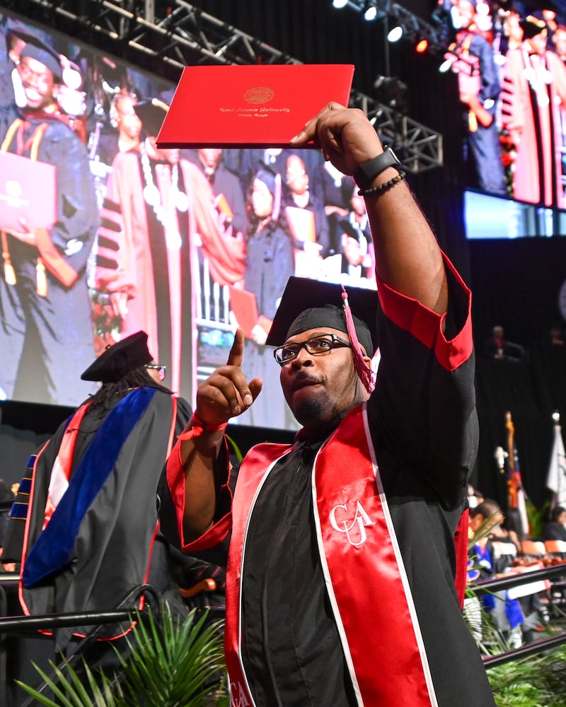 Elisco Edgers gestures as he walks across the stage during Clark Atlanta University’s 2025 commencement ceremony Sunday, May 18, 2025 at Georgia State’s Convocation Center. (Daniel Varnado/For the Atlanta Journal-Constitution)