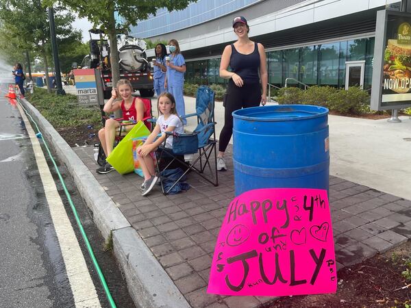 Claire Morris and her two daughters at "Cardiac Hill" along the route of the Atlanta Journal-Constitution Peachtree Road Race in Atlanta on Monday, July 4, 2022.