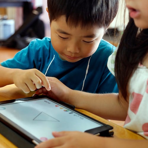 FILE - Children work on a digital program at Coby Preschool in Yoshikawa, suburban Tokyo, July 12, 2018. (AP Photo/Yuri Kageyama, File)