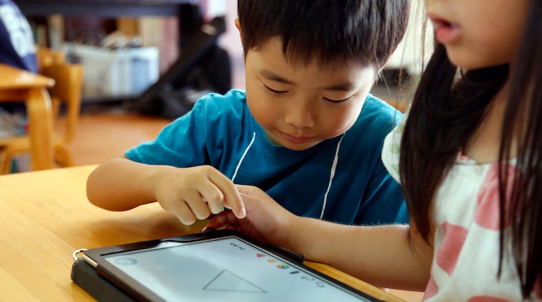 FILE - Children work on a digital program at Coby Preschool in Yoshikawa, suburban Tokyo, July 12, 2018. (AP Photo/Yuri Kageyama, File)