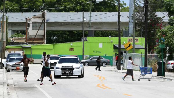 Police patrol a side street next to an apartment building in Miami’s Overtown neighborhood where a 10-year-old boy, who died from a fentanyl overdose last month, lived.