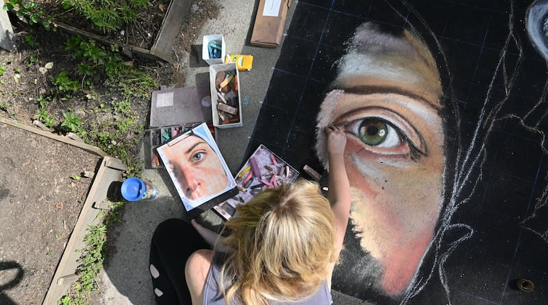 April 21, 2020 Atlanta - Jessi Queen draws a mammoth mural of a friend, who is an anesthesiologist working with COVID patients, at their home in East Atlanta on Tuesday, April 21, 2020. One woman and her friends are drawing a massive mural portrait of a friend who is a doctor placing people on ventilators. Another family is leaving messaged for those who feel isolated under social distancing orders. Chalk art creations are popping up all over the city. (Hyosub Shin / Hyosub.Shin@ajc.com)