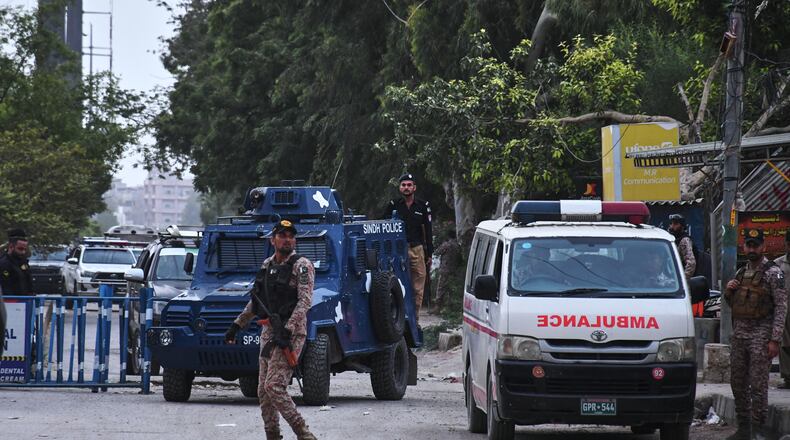 Paramilitary soldiers and police officers stand guard on a road cordoned off near the site of a militant attack at the provincial headquarters of the paramilitary Pakistan Rangers in Karachi, Pakistan, Sunday, June 28, 2026. (AP Photo/Ali Raza)