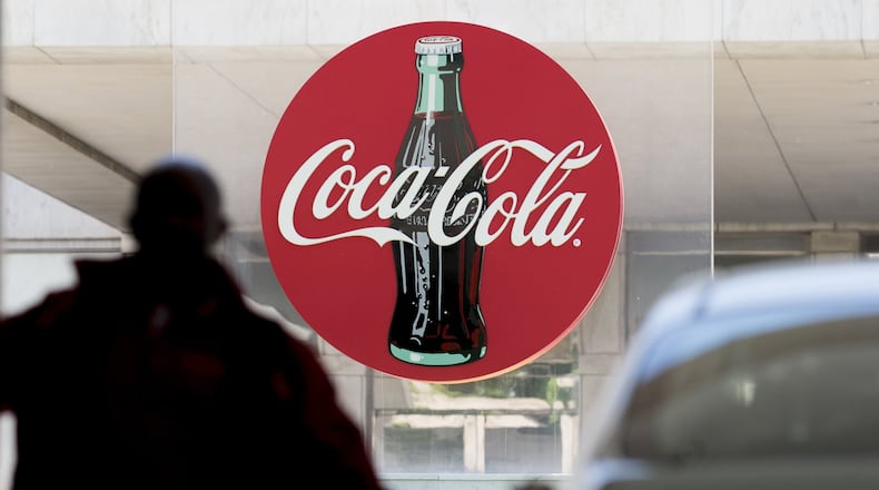 A parking attendant helps a guest at Coca-Cola’s headquarters after the Atlanta company announced its will cut 1,200 jobs later this year as part of an expanded cost-cutting program. (DAVID BARNES / DAVID.BARNES@AJC.COM)