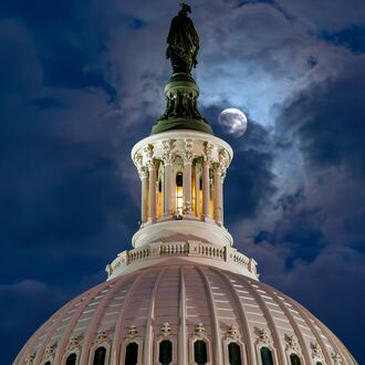 FILE - The moon emerges from the clouds over the U.S. Capitol dome in Washington, Dec. 2, 2025. (AP Photo/J. Scott Applewhite, File)