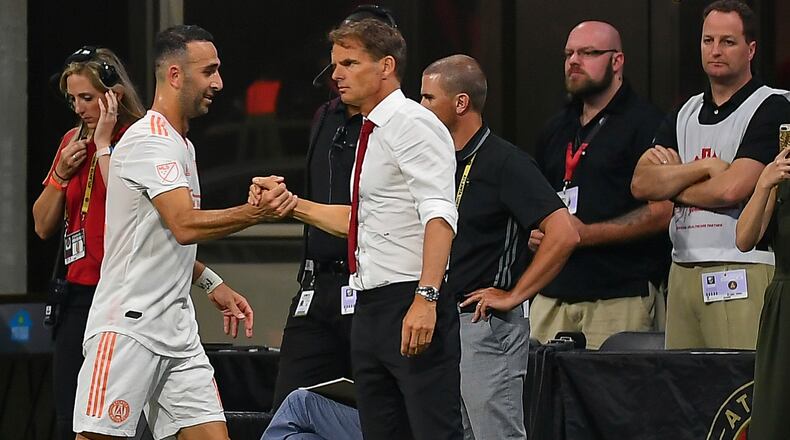 Atlanta United's Justin Meram (14) is congratulated by head coach Frank de Boer (right) after being subbed off against the Montreal Impact June 29, 2019, at Mercedes Benz Stadium in Atlanta.