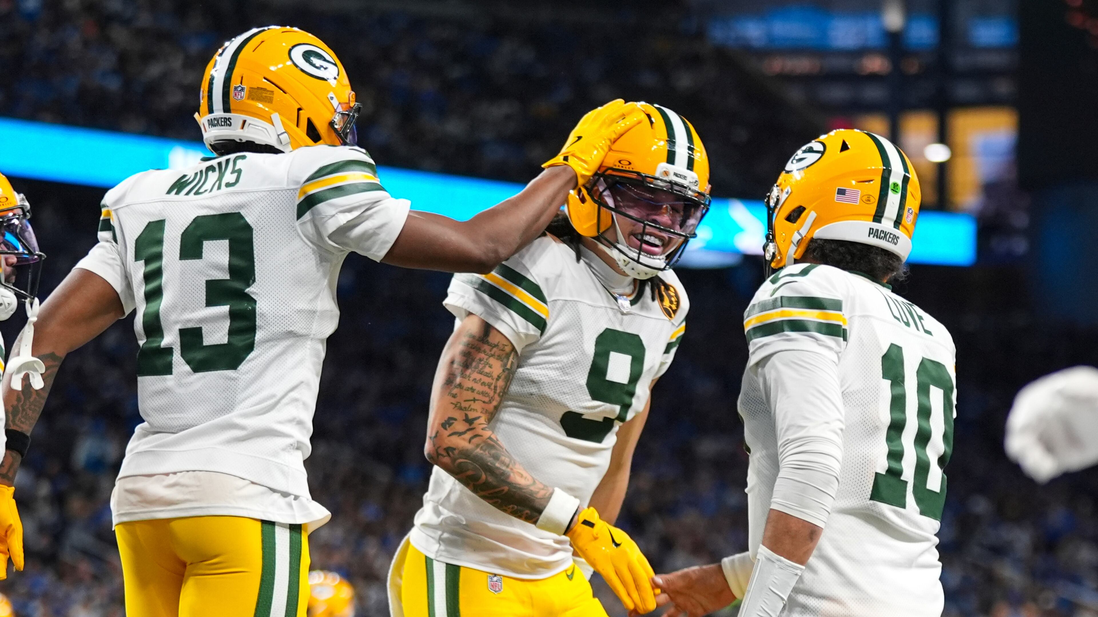 Green Bay Packers wide receiver Christian Watson (9) celebrates a touchdown with wide receiver Dontayvion Wicks (13) and quarterback Jordan Love (10) against the Detroit Lions during the second half an NFL football game in Detroit, Thursday, Nov. 27, 2025. (AP Photo/Ryan Sun)