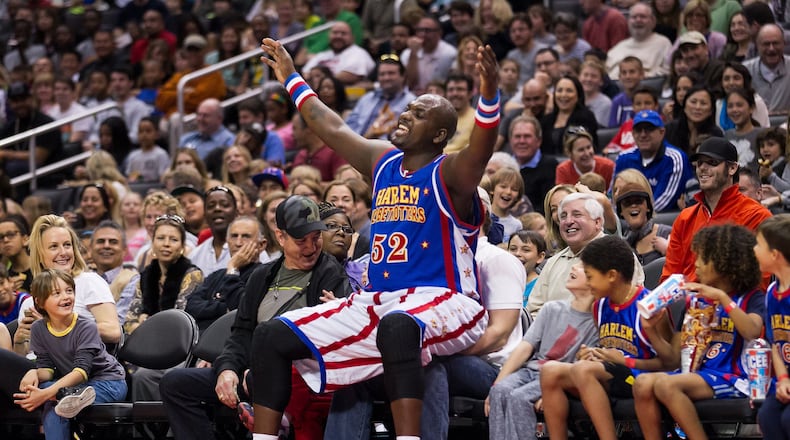 Harlem Globetrotter big man Big Easy Lofton, all 6-foot-9 and 250 pounds of him, playfully takes a courtside seat, ignoring the fan already sitting there. The Globetrotters cancelled games as the global pandemic surged. CONTRIBUTED BY HARLEM GLOBETROTTERS