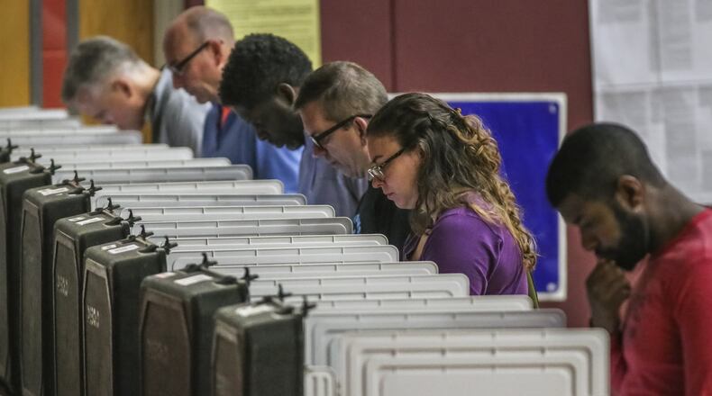 Voters pondered the ballots at Henry W. Grady High School in Atlanta on Tuesday May 22, 2018. JOHN SPINK/JSPINK@AJC.COM
