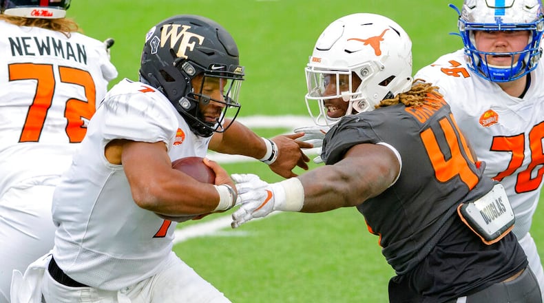 American Team quarterback Jamie Newman of Wake Forest (left) and Georgia runs against National Team defensive lineman Ta'Quon Graham of Texas (49). (AP Photo/Matthew Hinton)