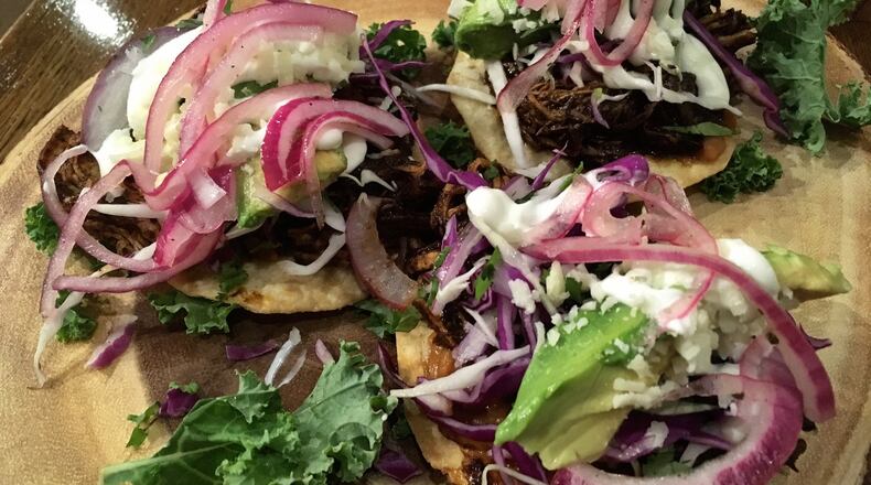 The chicken mole tostadas at Patria Cocina are garnished with pickled red onions, sour cream, cotija cheese and avocado. CONTRIBUTED BY WYATT WILLIAMS