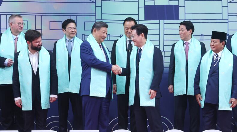 Chinese President Xi Jinping, center left, and South Korean President Lee Jae Myung, center right, shake hands after a group photo at the Asia-Pacific Economic Cooperation (APEC) Economic Leaders' Meeting in Gyeongju, South Korea, Saturday, Nov. 1, 2025. (Yonhap via AP)