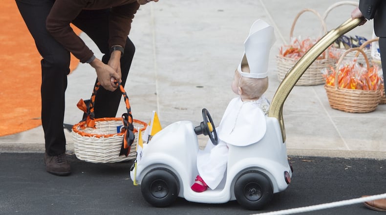 US President Barack Obama greets a young child dressed as the Pope and riding in a "Popemobile" as he hands out treats to children trick-or-treating for Halloween on the South Lawn of the White House in Washington, DC, October 30, 2015. AFP PHOTO / SAUL LOEB (Photo credit should read SAUL LOEB/AFP/Getty Images)