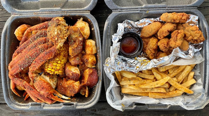 This takeout order from Infusion Crab ATL includes a combo of snow-crab clusters, shrimp, potatoes, corn on the cob and a boiled egg; and a dinner of fried oysters, fries and spicy drawn butter. Wendell Brock for The Atlanta Journal-Constitution