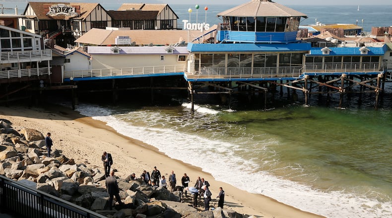 Police continue their investigation Thursday morning near the rocks below the Redondo Beach Pier after two people were shot and police killed the gunman.