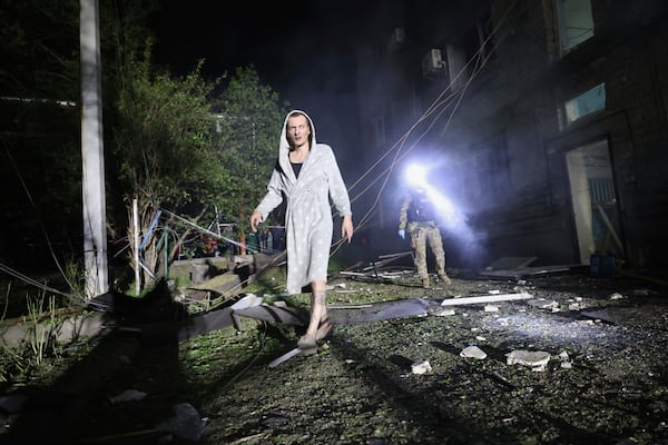 A man walks in a yard of a residential building destroyed by a Russian strike in Zaporizhzhia, Ukraine, Thursday, May 1, 2025. (AP Photo/Kateryna Klochko)