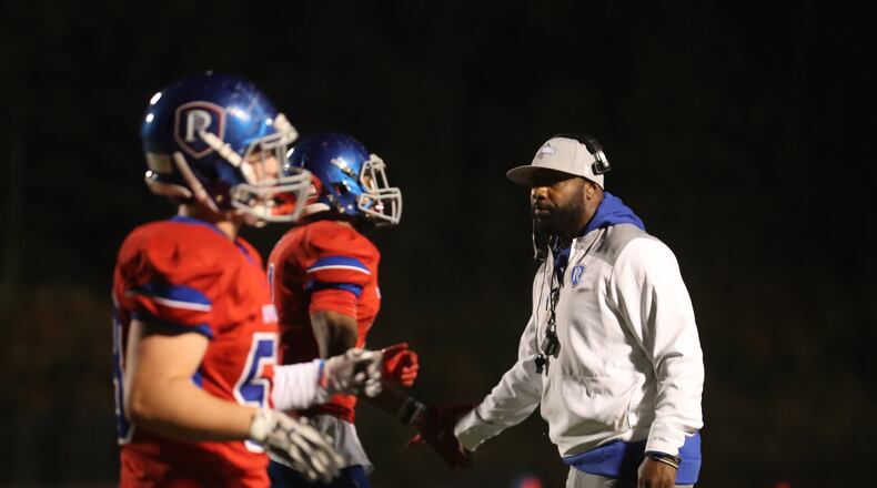 Riverwood coach Robert Edwards, the former University of Georgia and NFL running back, greets his players after a touchdown in a recent 21-6 victory over Carver-Atlanta. (Jason Getz/Special)