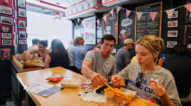People wearing World Cup shirts taste sandwiches at Pauli's sandwich shop in the North End of Boston, Wednesday, June 24, 2026. (AP Photo/Martin Meissner)