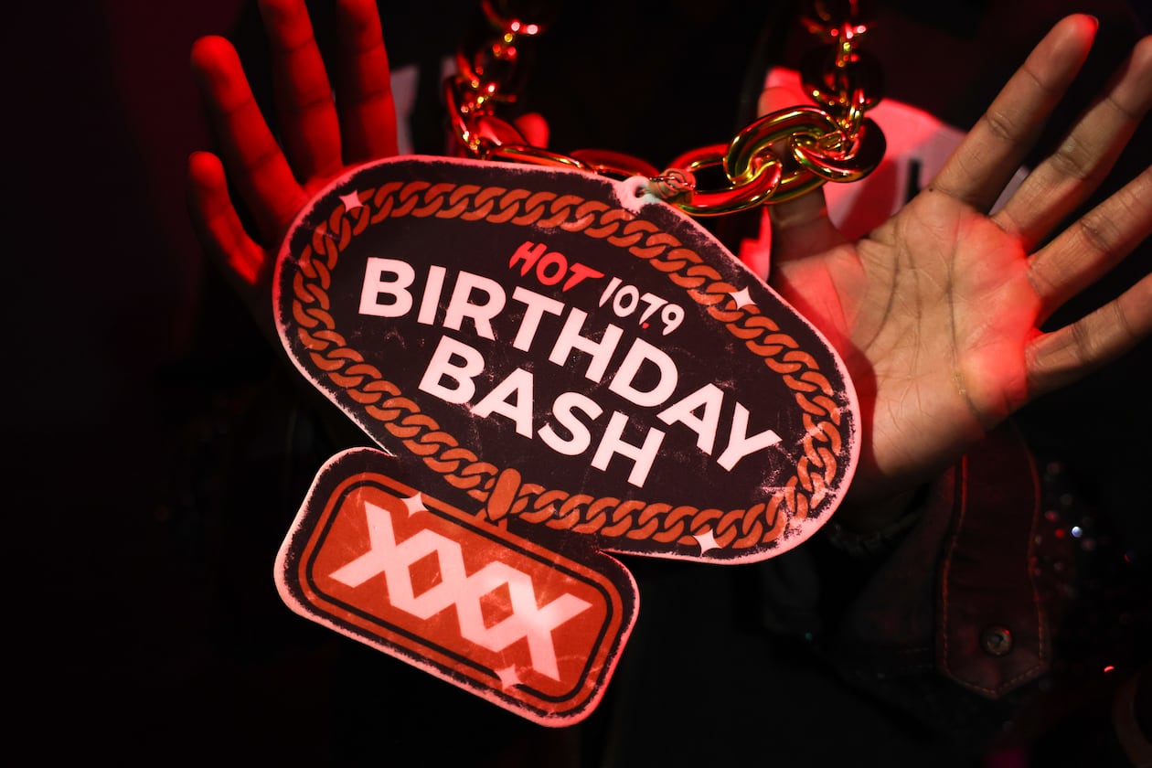 An attendee holds up a Birthday Bash pendant on a chain at the Hot 107.9 Who’s Hot showcase at Believe Music Hall in Atlanta on May 21, 2026. The showcase is leading up to the hip-hop station’s 30th Birthday Bash. (Arvin Temkar/AJC)