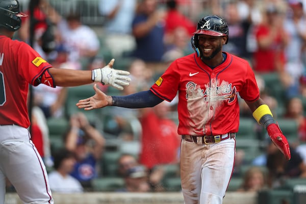 Atlanta Braves' Jurickson Profar, right, reacts after scoring a run in the first inning of a baseball game against the New York Yankees, Friday, July 18, 2025, in Atlanta. (AP Photo/Colin Hubbard)