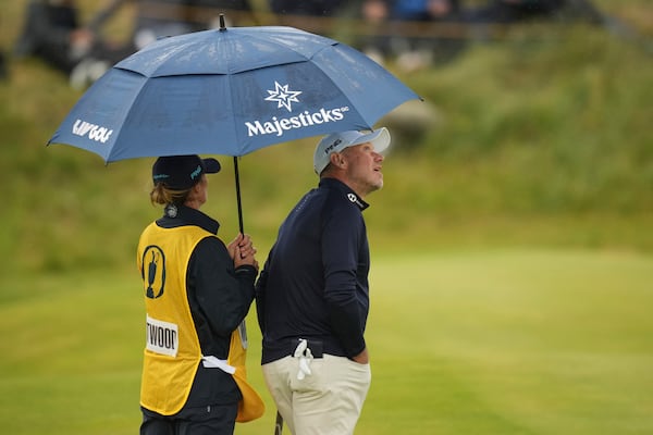 Lee Westwood of England looks out from his umbrella as he waits to play on the 7th green during the first round of the British Open golf championship at the Royal Portrush Golf Club, Northern Ireland, Thursday, July 17, 2025. (AP Photo/Francisco Seco)