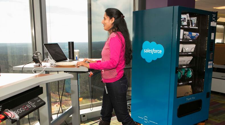 Prlya Pemmasani uses a treadmill desk next to an IT vending machine at Salesforce's Atlanta office. Salesforce was named the top large workplace in the 2016 Atlanta Top Workplaces project by The Atlanta Journal-Constitution. (Phil Skinner for the AJC)