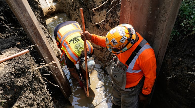 Workers install a copper pipe to replace a lead service line that brings drinking water to homes Tuesday, July 21, 2026, in Chicago. (AP Photo/Alyssa Goodman)