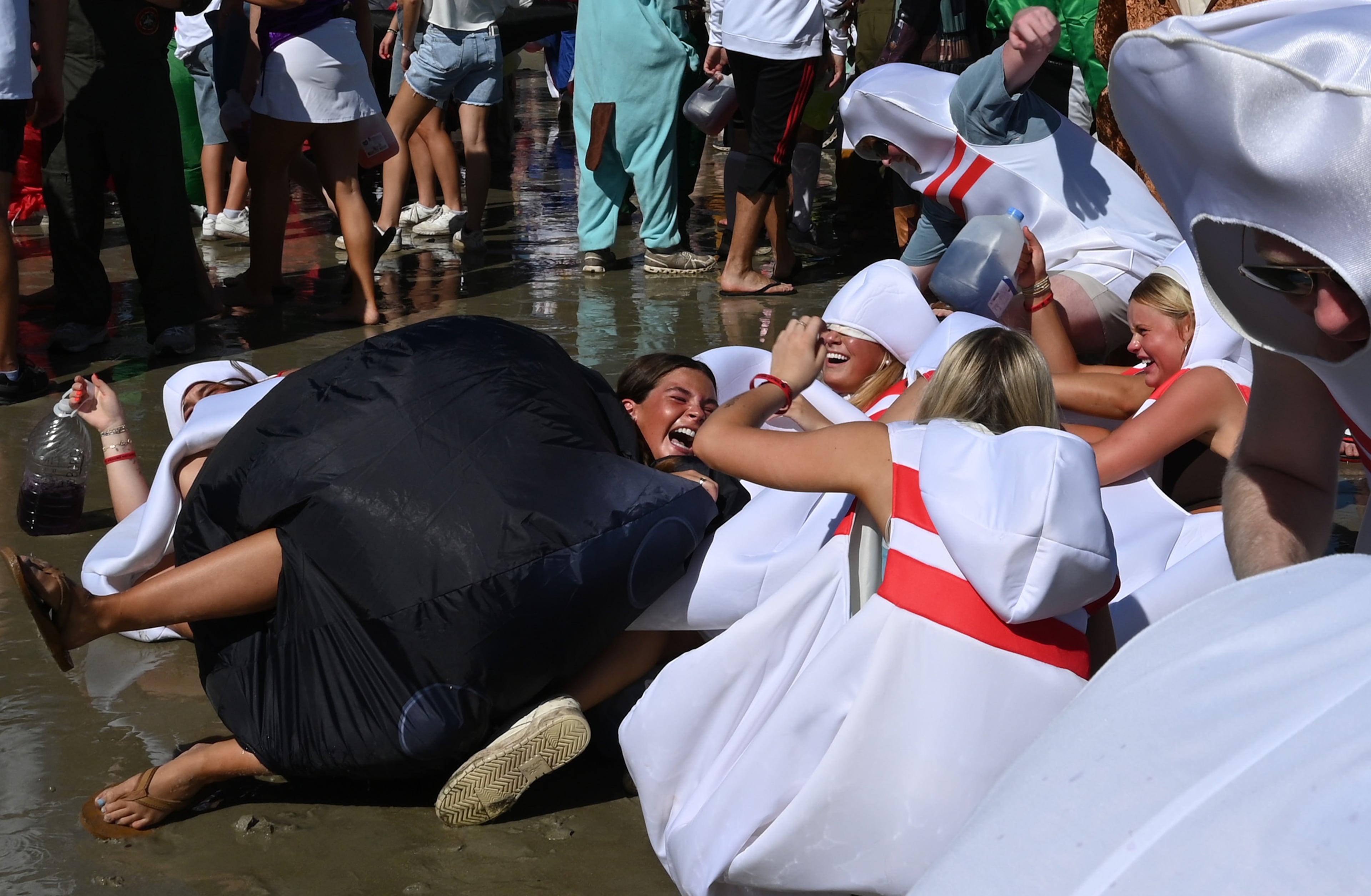 Simmons Key (left) crashes into human bowling pins during the annual “Frat Beach” party for the weekend of the Georgia-Florida football game on St. Simons Island, Friday, November 1, 2024. On the weekend of the Georgia-Florida football game, St. Simons Island’s East Beach becomes “Frat Beach,” an open-air party teeming with thousands of college students. (Hyosub Shin / AJC)