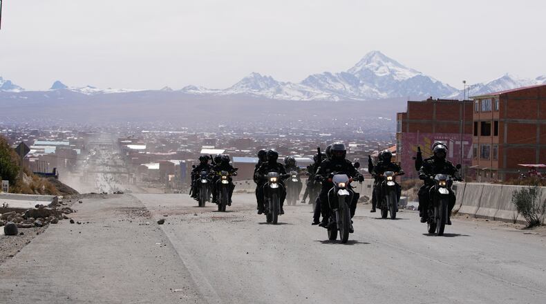 Police patrol a highway after President Rodrigo Paz declared a state of emergency to empower the military to remove road blockades, in El Alto, Bolivia, Saturday, June 20, 2026. (AP Photo/Juan Karita)