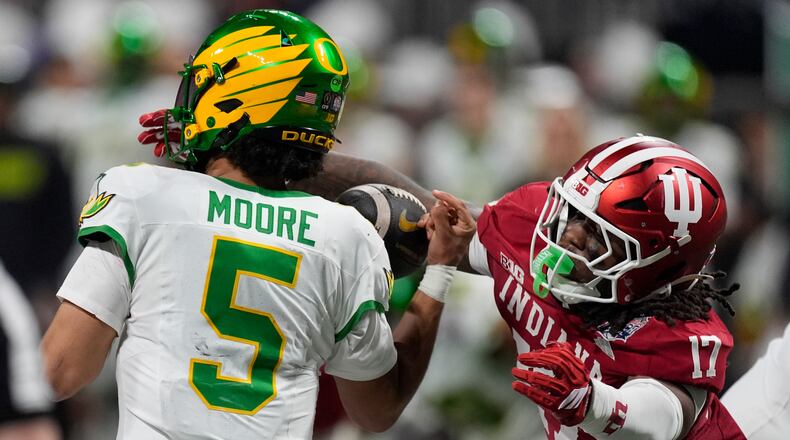 Indiana defensive lineman Daniel Ndukwe (17) pressures Oregon quarterback Dante Moore (5) during the first half of the Peach Bowl NCAA college football playoff semifinal, Friday, Jan. 9, 2026, in Atlanta. (AP Photo/Mike Stewart)