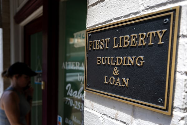 A person walks into the store next to First Liberty Building & Loan in downtown Newnan on Wednesday, July 2, 2025. (Arvin Temkar/AJC)