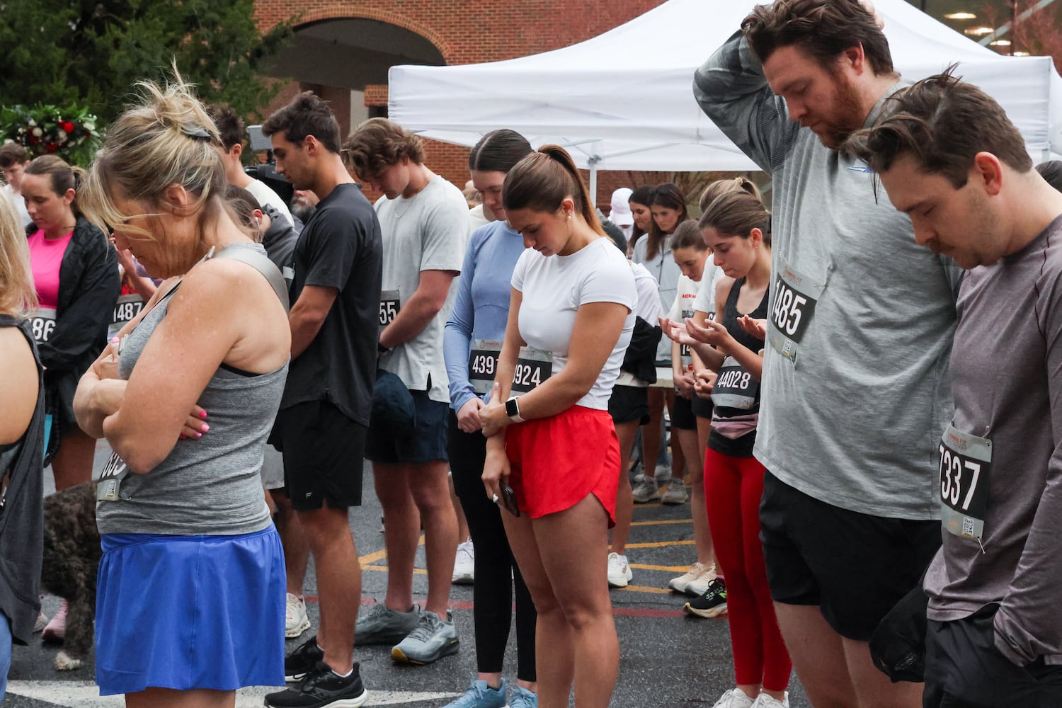 Runners bow their heads on Saturday, Feb. 21, 2026, before a 5K walk/run and memorial service on the UGA campus for Augusta University nursing student Laken Riley. Riley was attacked on Feb. 22, 2024 while running in Oconee Forest Park on the UGA campus and killed. Riley had previously attended UGA and was an avid runner. (C.J. Bartunek for the AJC)
