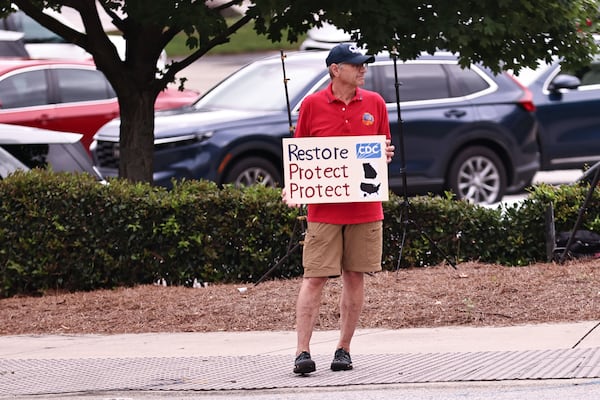 Former Centers for Disease Control and Prevention employee Steve Monroe holds up a sign in protest during Health and Human Services Secretary Robert F. Kennedy Jr.’s CDC visit on Monday, Aug. 11, 2025. (Natrice Miller/ AJC)