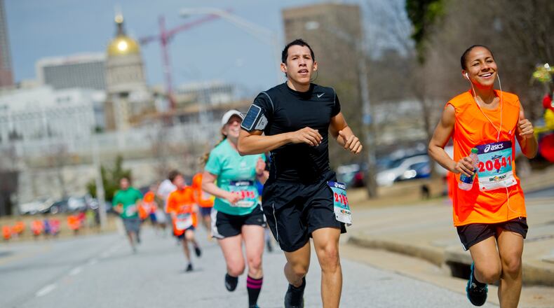 Jordan Zambrana (left) and Christiane Nolton run as they near the finish line for the Hunger Walk/Run 2013 through downtown Atlanta. More than 15,000 runners and walkers participated in the 29th annual fundraiser to raise money for the Atlanta Community Food Bank and five other non-profit organizations.
