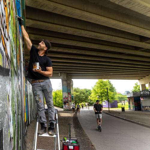 Artist DasBK paints a mural along the Beltline near the Historic Fourth Ward Skate Park. In recent years, the city of Atlanta has made meaningful commitments to parks funding, guest columnist Michael Halicki writes. (John Spink/AJC 2024)