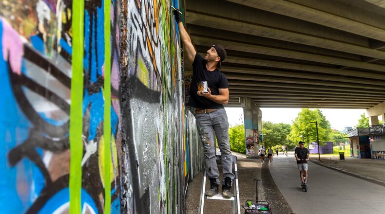 Artist DAS.BK begins a new painting, "Tribute to Atlanta," along the Atlanta Beltline on April 26. (John Spink/Atlanta Journal-Constitution)