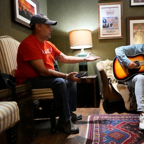 Army veteran Clay Jensen, left, talks about events in his military career as songwriter Brian White, right, puts them into lyrics as they work in a dressing room in the Grand Ole Opry House as part of the CreatiVets program on Tuesday, Sept. 8, 2025, in Nashville, Tenn. (AP Photo/Mark Humphrey)