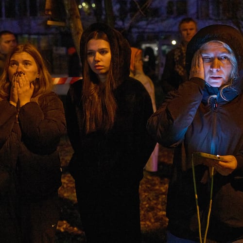 Local residents react as they watch their burning home after a drone hit a multi-storey residential building during Russia's night drone attack in Kyiv, Ukraine, Tuesday, Nov. 25, 2025. (AP Photo/Efrem Lukatsky)