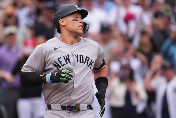 New York Yankees' Aaron Judge heads back to the dugout after touching home plate following his solo home run off Colorado Rockies starting pitcher Kyle Freeland in the first inning of a baseball game Saturday, May 24, 2025, in Denver. (AP Photo/David Zalubowski)