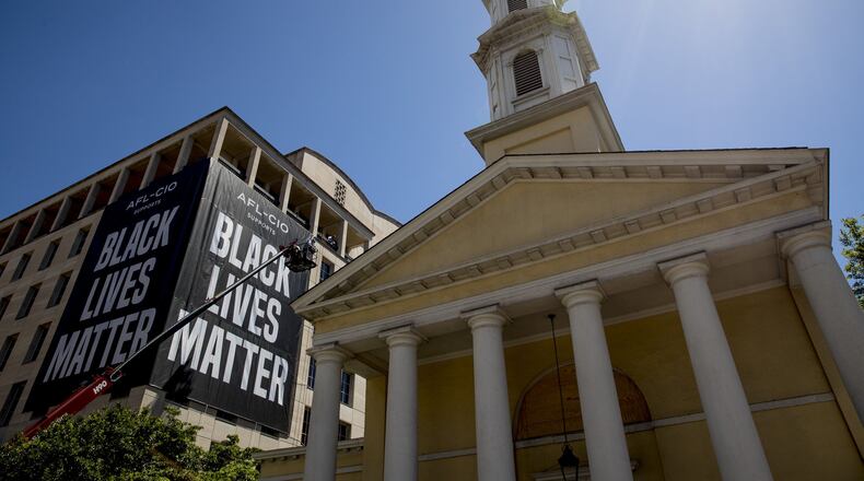 St. John’s Episcopal Church is visible as a large banner that reads Black Lives Matter is hung from the AFL-CIO building on part of 16th Street renamed Black Lives Matter Plaza, a site of protests, Friday, June 12, 2020, near the White House in Washington. The protests began over the death of George Floyd, a black man who was in police custody in Minneapolis. Floyd died after being restrained by Minneapolis police officers. (AP Photo/Andrew Harnik)